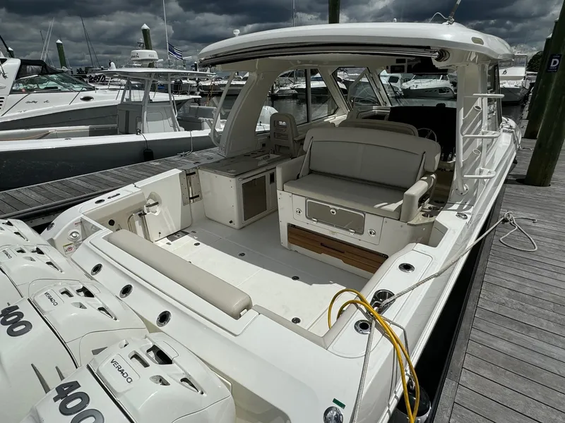 Slide: The Image of 2020 Boston Whaler 380 Realm boat docked, showcasing spacious deck and seating area. - 13