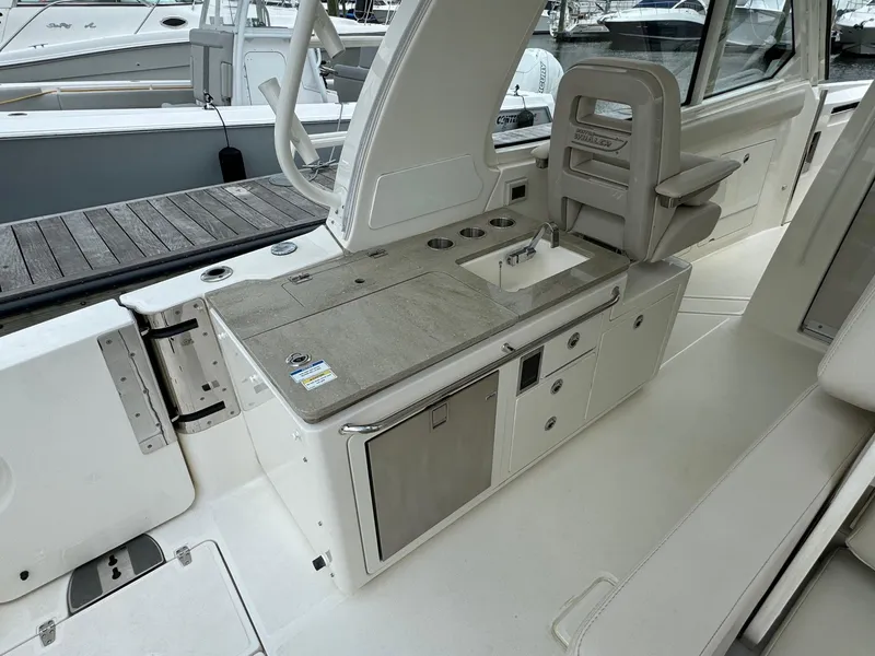 Slide: The Image of 2020 Boston Whaler 380 Realm boat interior with sink and storage compartments. - 17