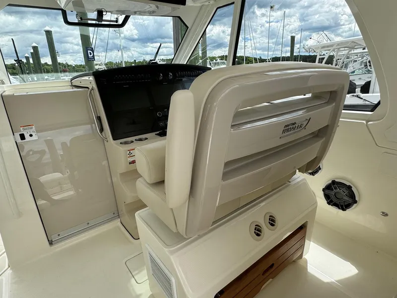 Slide: The Image of 2020 Boston Whaler 380 Realm helm station with captain's chair and navigation controls. - 24