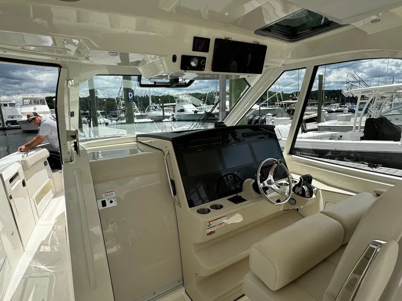 Slide: The Image of Interior helm of a 2020 Boston Whaler 380 Realm boat at a marina. - 25