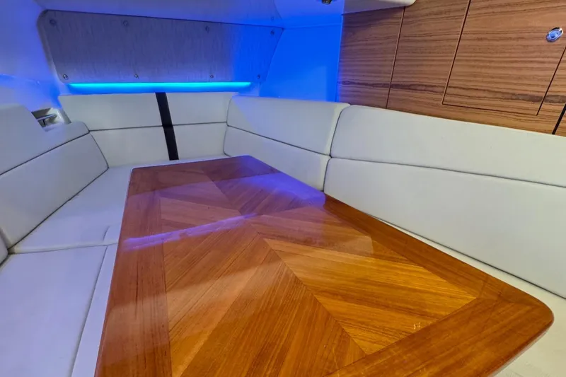 Slide: The Image of Interior cabin of a 2020 Boston Whaler 380 Realm with wooden table and cushioned seating. - 42