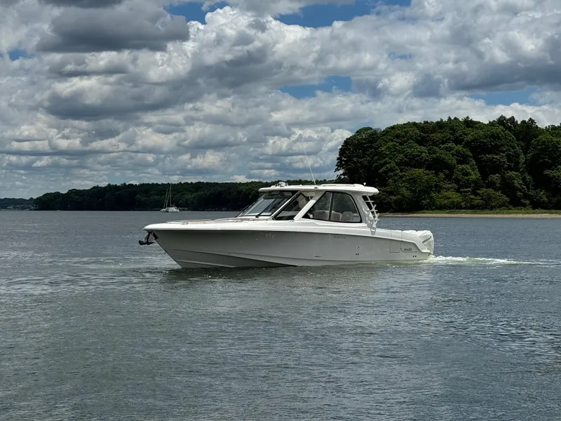 Slide: The Image of 2020 Boston Whaler 380 Realm cruising on a calm lake under a partly cloudy sky. - 9