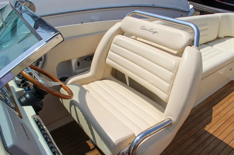 Slide: The Image of Interior seating of 2013 Chris-Craft Launch 28 boat with beige upholstery and cup holder. - 18