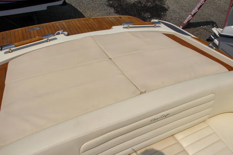 Slide: The Image of 2013 Chris-Craft Launch 28 boat with wooden deck and branded seating at a marina. - 28