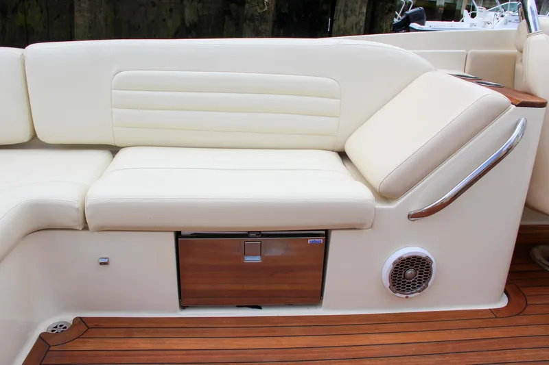 Slide: The Image of 2013 Chris-Craft Launch 28 boat interior with beige seating and wooden accents. - 52