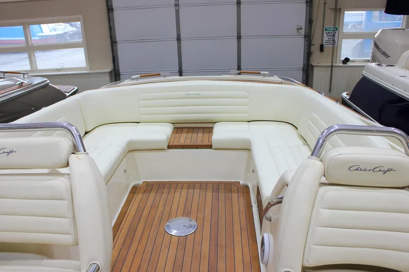 Slide: The Image of 2013 Chris-Craft Launch 28 boat interior with white seating and wooden flooring. - 63
