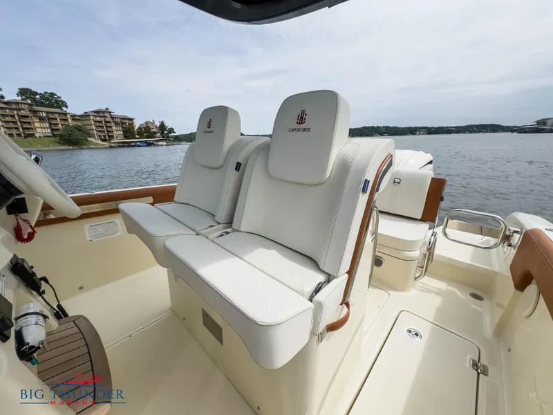 Slide: The Image of 2024 Capoforte FX240 boat interior with white leather seats on a lake. - 24