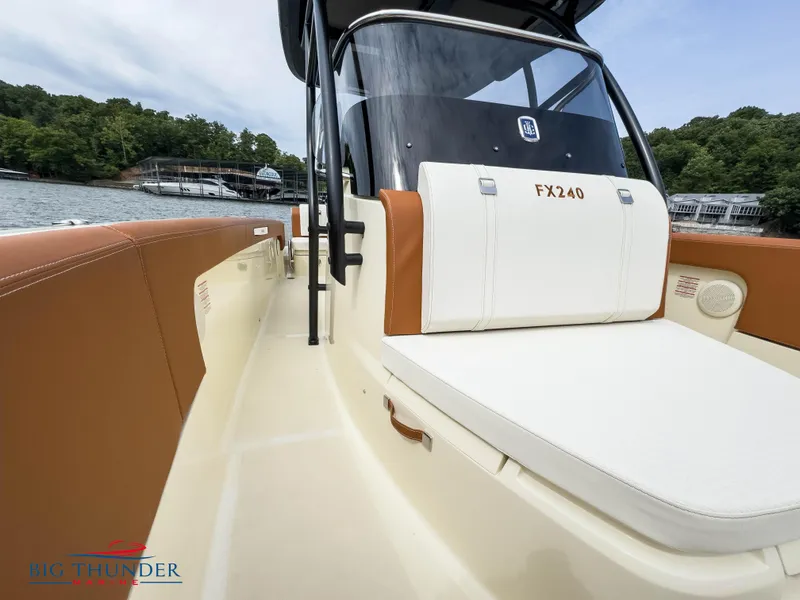 Slide: The Image of 2024 Capoforte FX240 boat interior with white and brown seating, docked near a marina. - 29