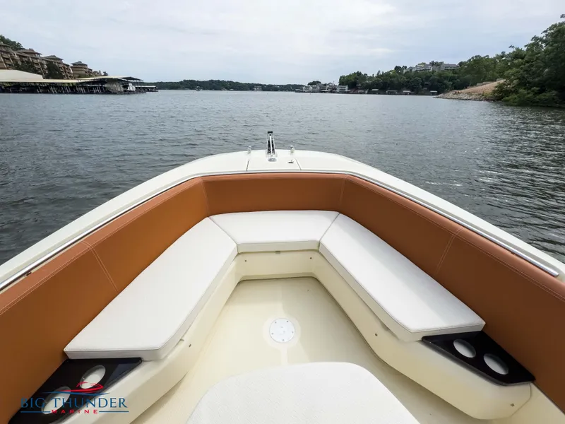Slide: The Image of 2024 Capoforte FX240 boat with cushioned seating on a calm lake. - 31