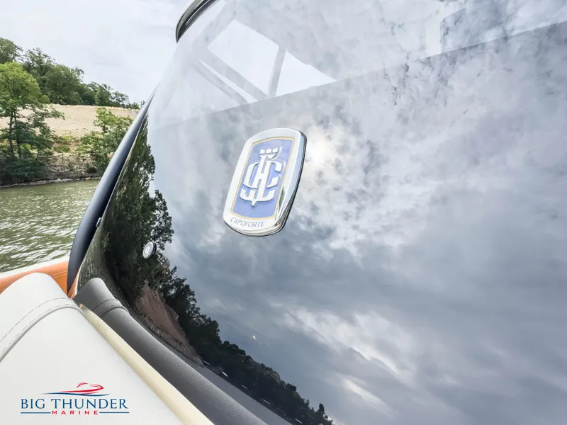 Slide: The Image of 2024 Capoforte FX240 boat with logo, Big Thunder Marine, lake and trees in background. - 32