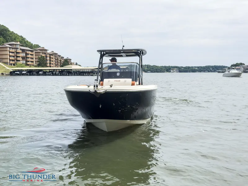Slide: The Image of 2024 Capoforte FX240 boat cruising on a lake near waterfront buildings. - 4