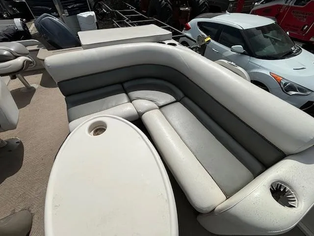 Slide: The Image of 2004 Crestliner 2485 LSI boat interior with white and gray seating and table. - 11