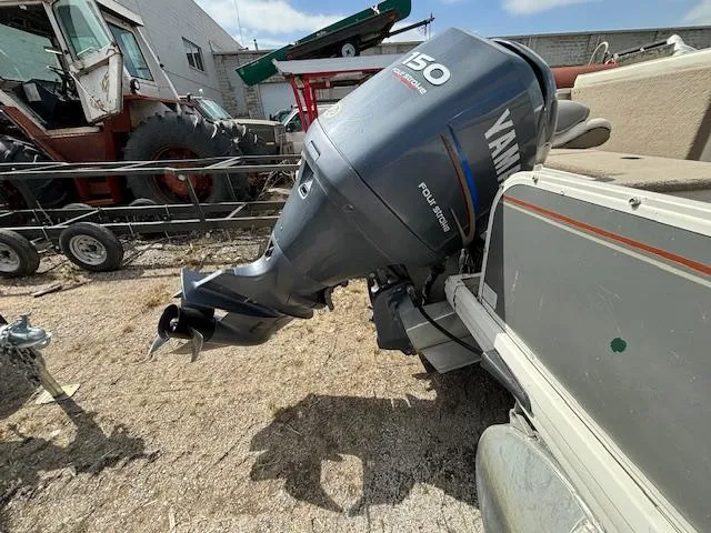 Slide: The Image of 2004 Crestliner 2485 LSI with Yamaha 150 outboard motor in a yard. - 2