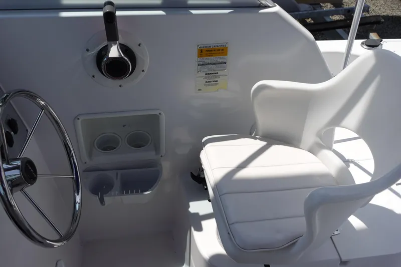 Slide: The Image of 1999 Pro-Line 221 Walk boat cockpit with steering wheel and white captain's chair. - 12