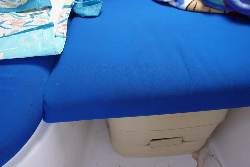 Slide: The Image of 1999 Pro-Line 221 Walk boat interior with blue seating and storage compartment. - 15