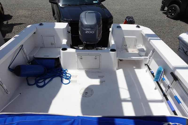 Slide: The Image of 1999 Pro-Line 221 Walk boat deck with Yamaha 200 outboard motor, featuring storage and fishing gear. - 2