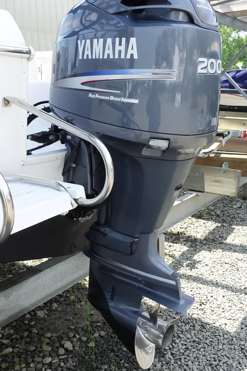 Slide: The Image of 1999 Pro-Line 221 Walk with Yamaha 200 outboard motor, parked on gravel. - 22