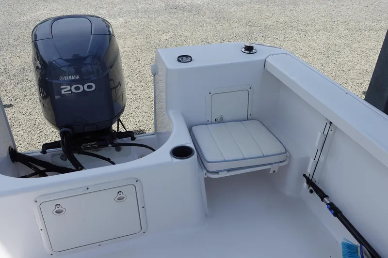 Slide: The Image of 1999 Pro-Line 221 Walk boat interior with Yamaha 200 engine, featuring seating and storage. - 4