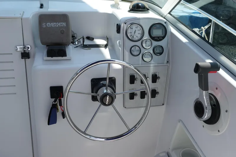 Slide: The Image of 1999 Pro-Line 221 Walk boat dashboard with steering wheel and control panel. - 6