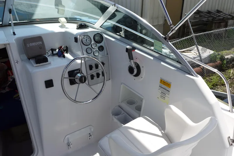 Slide: The Image of 1999 Pro-Line 221 Walk boat cockpit with steering wheel and control panel. - 7