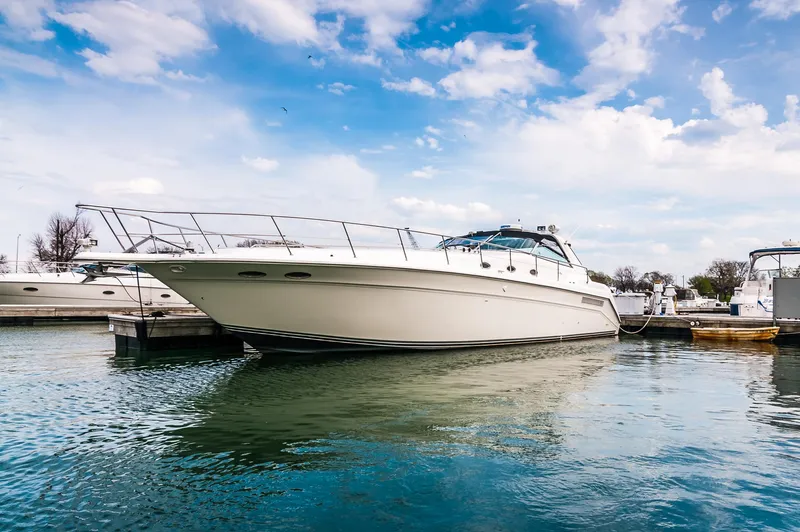The Image of 1994 Sea Ray 500 Sundancer yacht docked in a marina under a blue sky. - 0