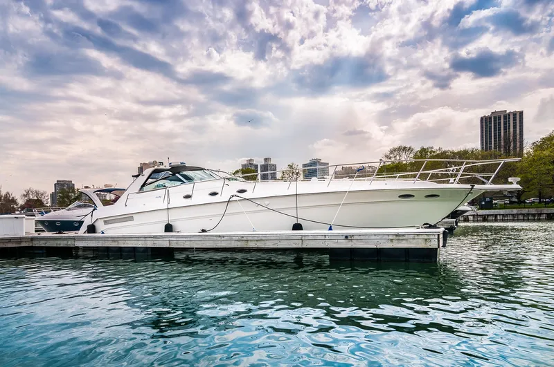 Slide: The Image of 1994 Sea Ray 500 Sundancer yacht docked at a marina under a cloudy sky. - 1