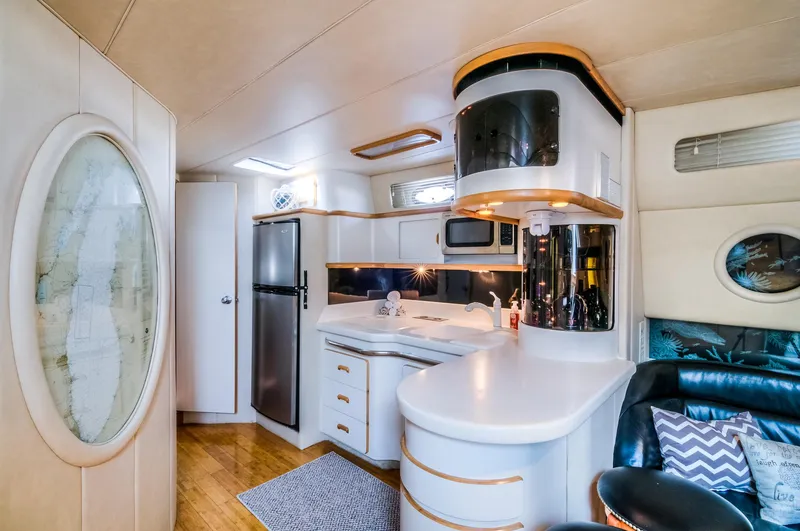 Slide: The Image of Interior of 1994 Sea Ray 500 Sundancer yacht with modern kitchen and seating area. - 19