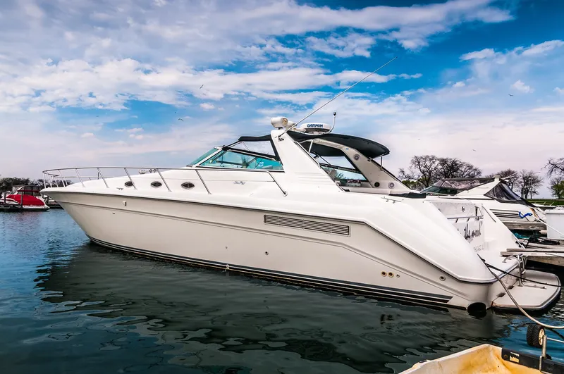 Slide: The Image of 1994 Sea Ray 500 Sundancer yacht docked in a marina under a blue sky. - 2