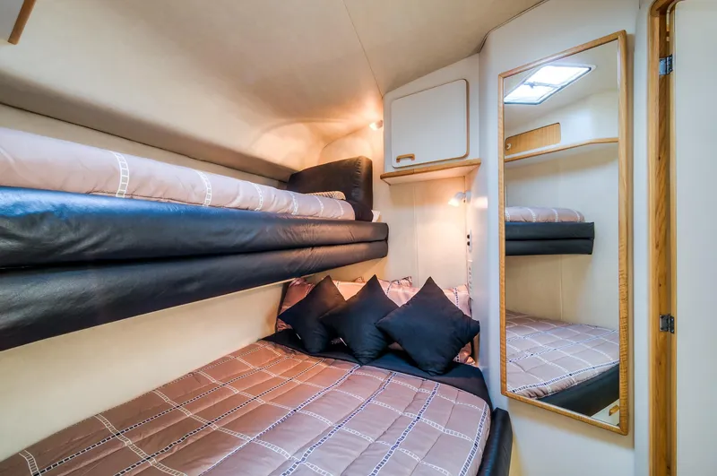 Slide: The Image of 1994 Sea Ray 500 Sundancer cabin with bunk beds and mirror. - 21