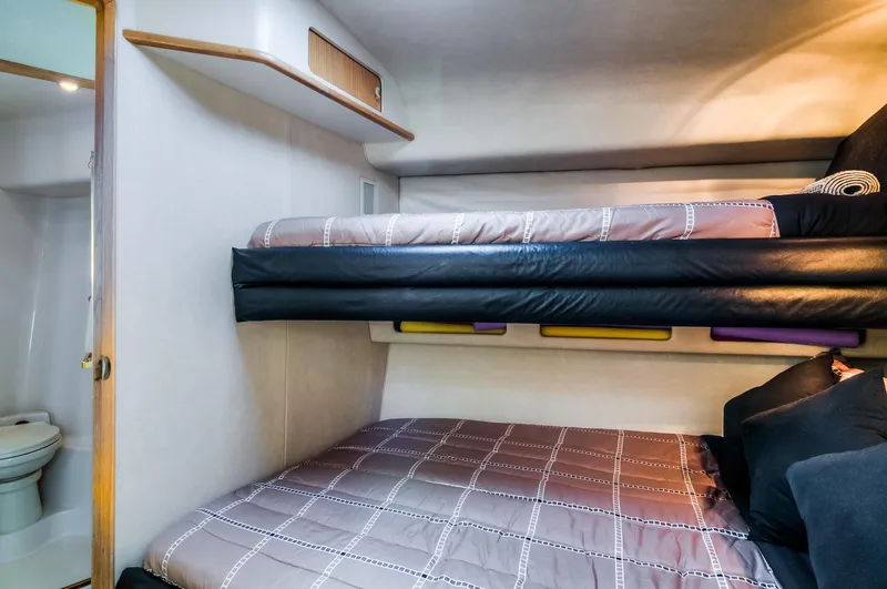 Slide: The Image of 1994 Sea Ray 500 Sundancer cabin with bunk beds and adjacent bathroom. - 22