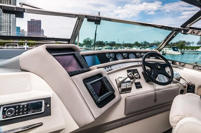 Slide: The Image of Helm of 1994 Sea Ray 500 Sundancer with modern navigation equipment and city skyline in background. - 5