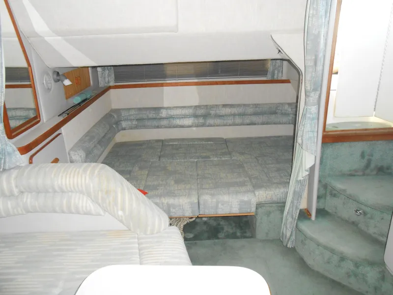 Slide: The Image of 1991 Sea Ray Sundancer 310 interior cabin with seating and sleeping area. - 13