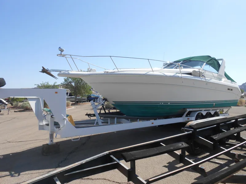 Slide: The Image of 1991 Sea Ray Sundancer 310 on a trailer in a parking lot. - 2