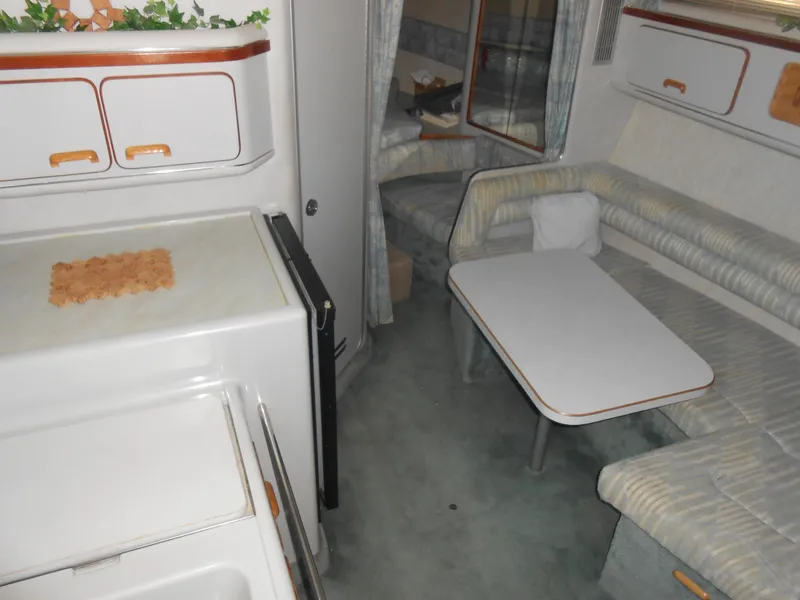 Slide: The Image of 1991 Sea Ray Sundancer 310 interior with kitchenette and seating area. - 8
