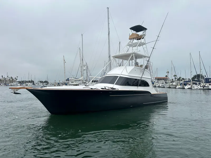 Slide: The Image of 1991 Buddy Davis Convertible yacht cruising in a calm harbor under clear blue skies. - 1