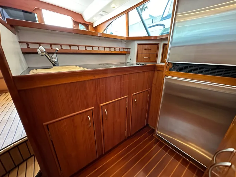 Slide: The Image of 1991 Buddy Davis Convertible yacht interior with wooden cabinetry and leather seating. - 11
