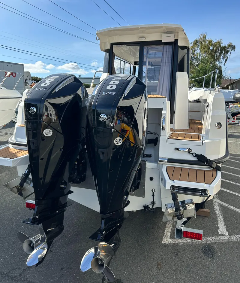 Slide: The Image of 2024 Parker Poland 800 Pilothouse boat with dual outboard engines, docked outdoors. - 5