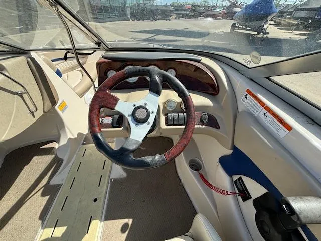 Slide: The Image of 2004 Glastron GX 185 boat interior with steering wheel and dashboard controls. - 12