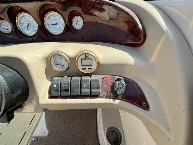 Slide: The Image of Dashboard controls of a 2004 Glastron GX 185 boat with gauges and switches. - 13