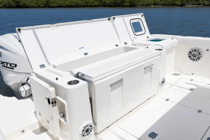 Slide: The Image of 2025 Pursuit OS 405 boat deck with storage and engine, on calm water. - 12