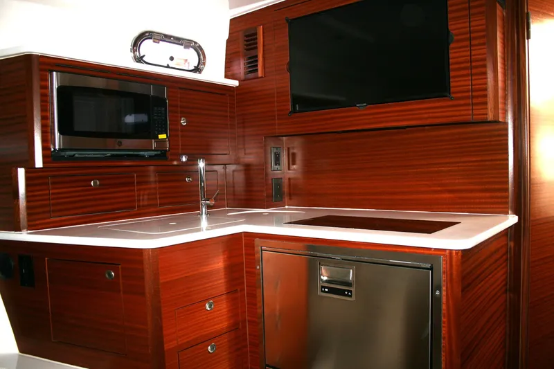 Slide: The Image of Luxurious 2025 Pursuit OS 405 Offshore yacht kitchen with modern appliances and sleek wood finish. - 20