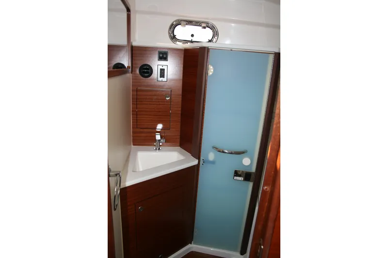 Slide: The Image of 2025 Pursuit OS 405 Offshore yacht bathroom with sink and frosted glass door. - 22