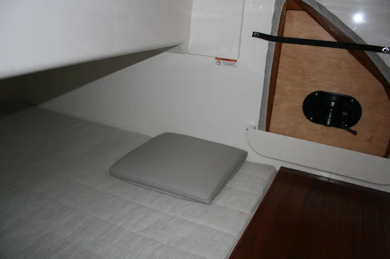 Slide: The Image of Interior cabin of 2025 Pursuit OS 405 Offshore boat, featuring cushioned seating and wooden accents. - 24