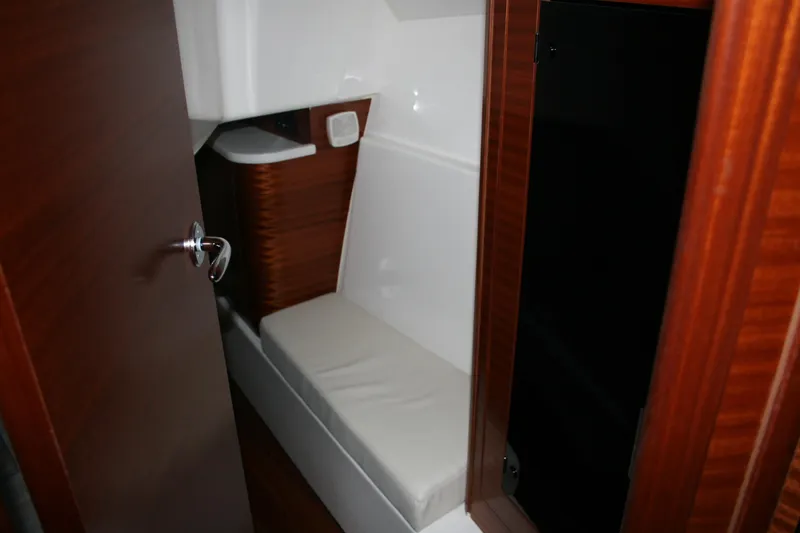 Slide: The Image of 2025 Pursuit OS 405 Offshore cabin interior with wooden finish and cushioned seating. - 25