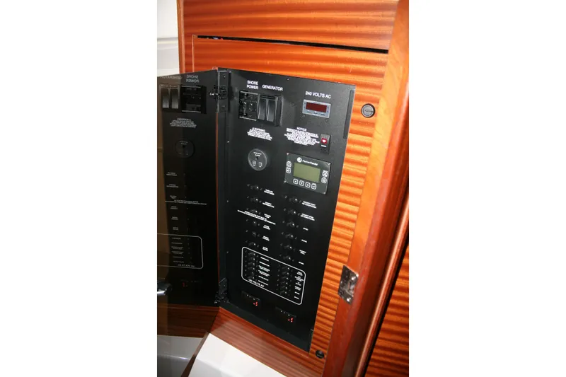 Slide: The Image of Electrical panel inside 2025 Pursuit OS 405 Offshore boat, featuring control switches and digital display. - 26