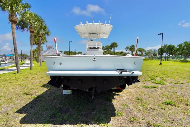 Slide: The Image of 1993 Ocean Runner 27 CC boat on grassy area with palm trees and blue sky. - 24