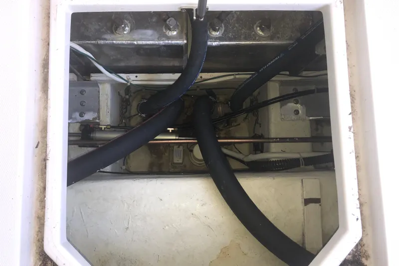 Slide: The Image of Engine compartment of a 2005 Carver 41 Cockpit Motor Yacht with visible hoses and wiring. - 12