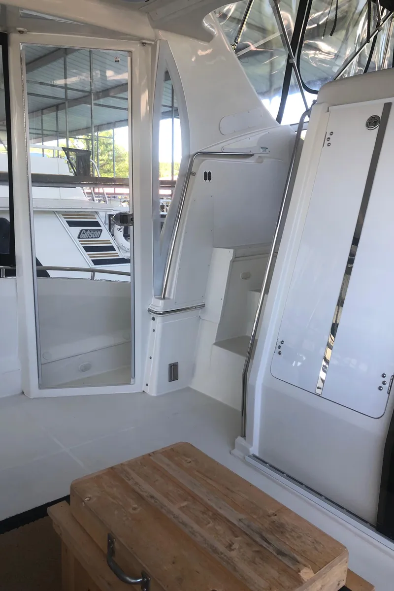 Slide: The Image of 2005 Carver 41 Cockpit Motor Yacht interior with white seating and wooden table. - 16