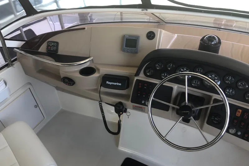 Slide: The Image of 2005 Carver 41 Cockpit Motor Yacht helm with steering wheel and navigation instruments. - 26