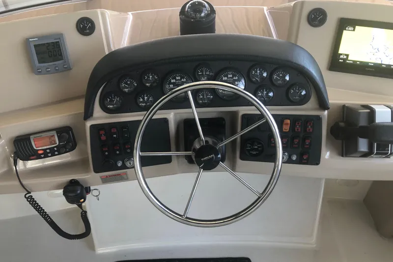 Slide: The Image of 2005 Carver 41 Cockpit Motor Yacht helm with steering wheel and navigation instruments. - 33